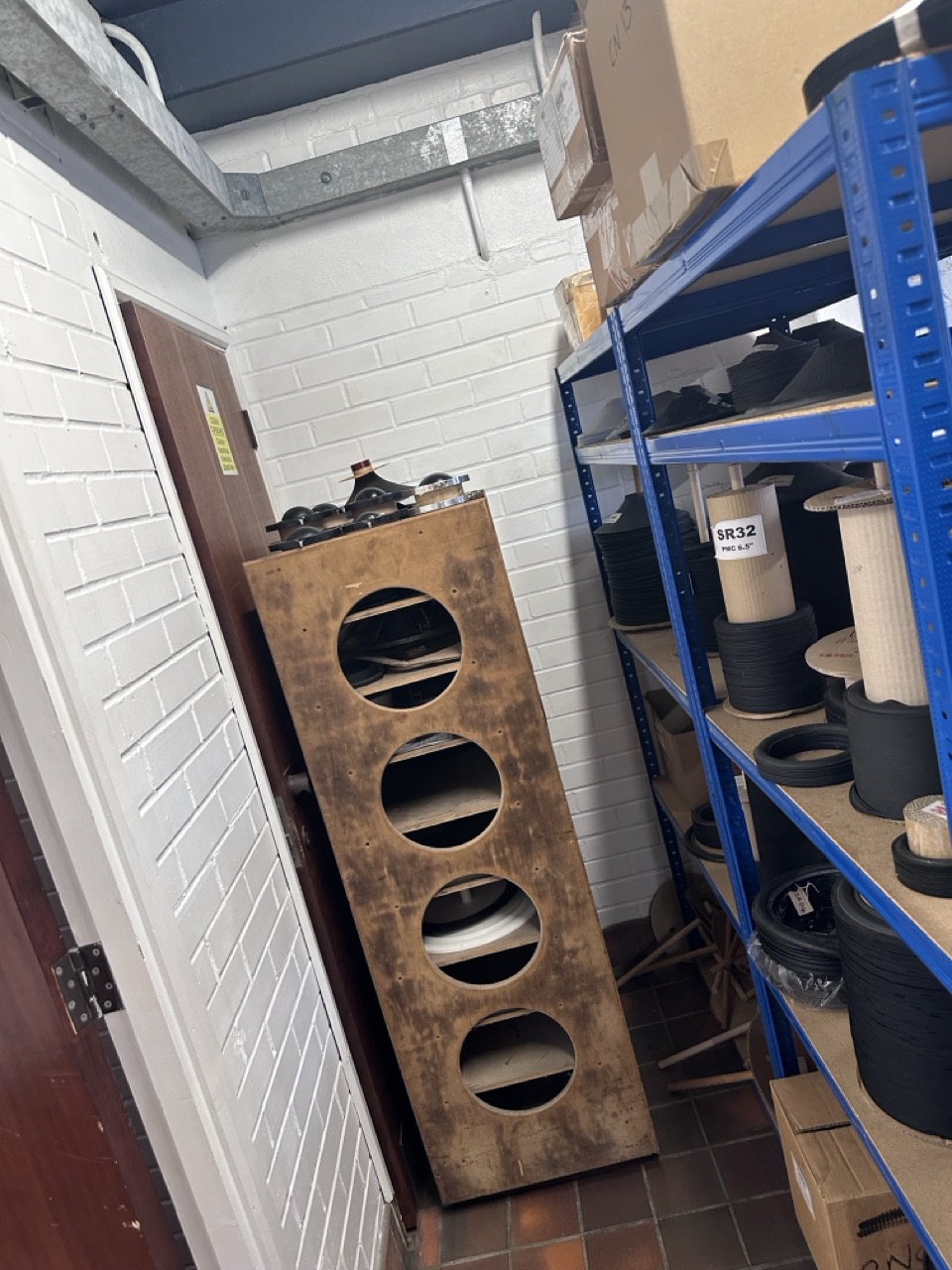 An old drive unit testing rig, re-purposed as shelving, in the foam surround storage area.